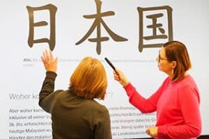 Kursleitende arbeiten am Smartboard