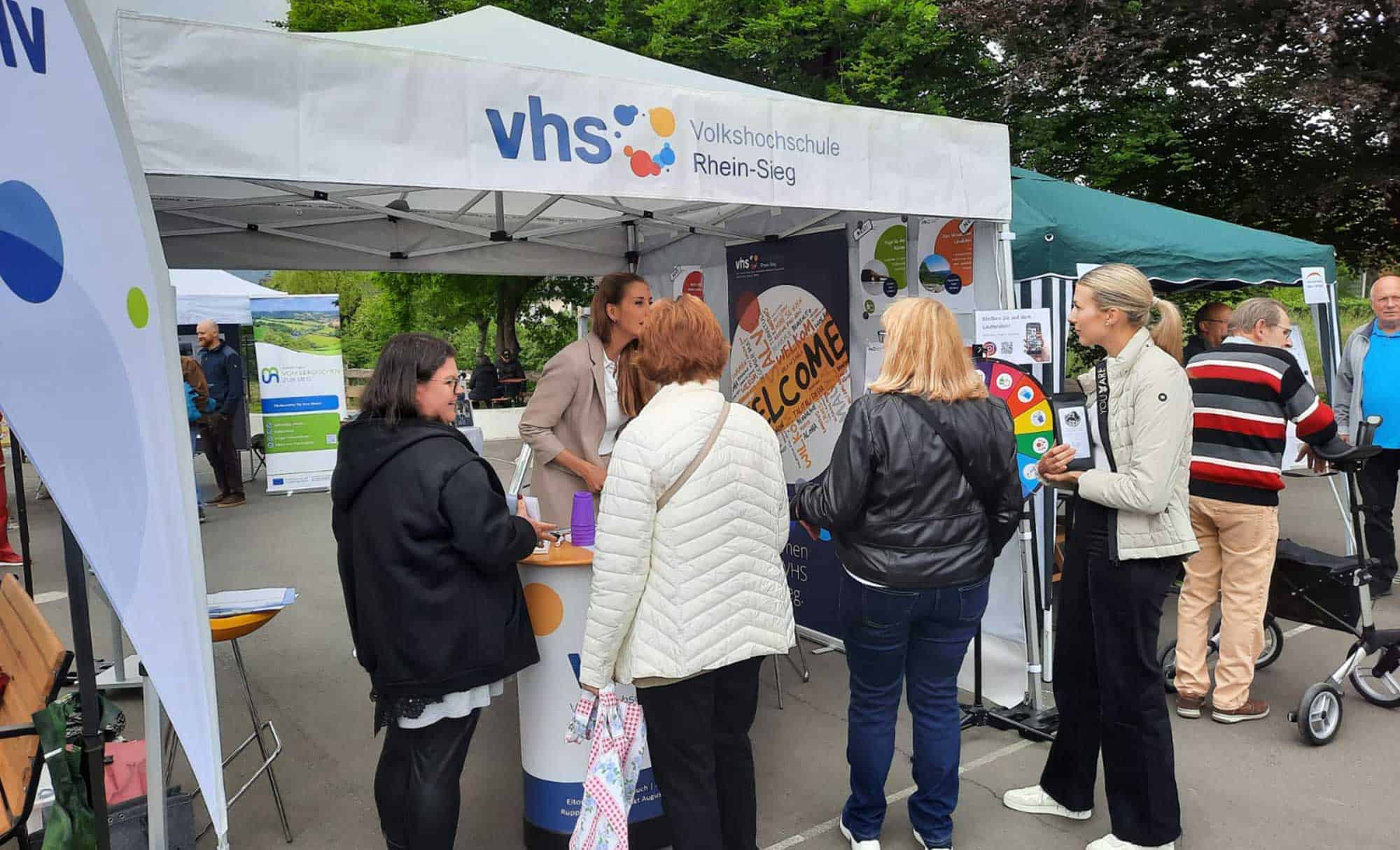 Ankündigung vhs-Stand Familienfest Ruppichteroth vhs-Mitarbeitende am Stand